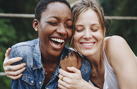 Two friends embracing one each other and smiling