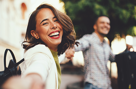 woman smiling while holding hands with friends