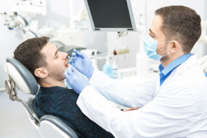 man with open mouth being operated on by a dentist, specialty dental services pasadena tx