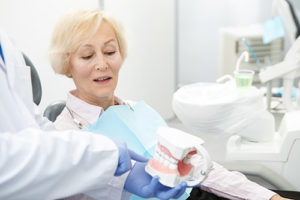 older woman being told about dentures by dentist, general dentistry pasadena tx