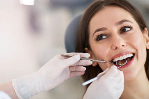 woman in dentist chair with instruments in mouth for periodontics pasadena tx