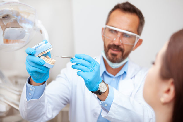dentist showing causes of receding gums