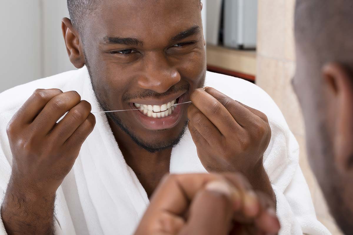a man trying to treat gingivitis by flossing